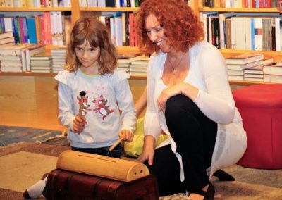 Autorin mit Kind bei Lesung spielt Instrument