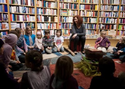 Kinder sitzen im Kreis beim Lesen