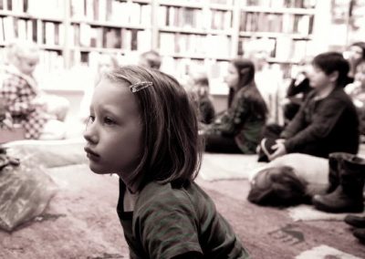 Mädchen hört aufmerksam bei Lesung zu