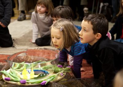 Kinder betrachten leuchtende Figuren im Kreis
